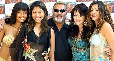 Vijay Mallya, chairman of United Breweries, poses with top Indian models featuring on new 2004 special swimsuit calendar, during its launch in Mumbai 