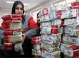Iraq central bank workers stack bundles of old notes printed with the face of Saddam Hussein and marked with red ink after they ceased to be legal tender