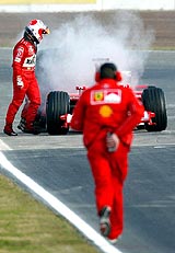 Formula One driver Brazilian Rubens Barrichello gets out of his car after a fire in his Ferraris engine at Montmelo racetrack