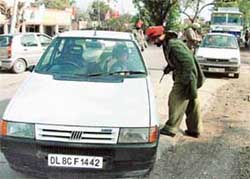 Morinda police personnel check cars at the barrier on the national highway in the wake of the jailbreak by the Beant Singh murder accused on Thursday. 