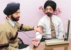 A doctor examines a senior citizen at a health camp organised at a slimming centre