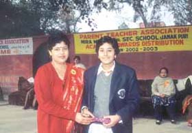 A meritorious student receiving an award during a function of the Parents Teachers Association (PTA) of Mira Model School