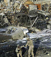 US soldiers take evidence samples from a bomb crater in front of the area of an explosion at a Baghdad hotel