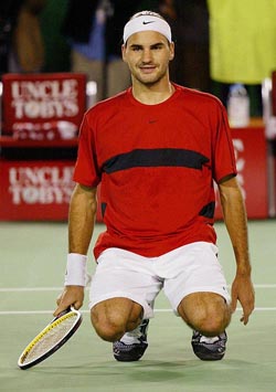 Switzerland's Roger Federer falls to his knees on center court as he celebrates his semifinal win over Spain's Juan Carlos Ferrero at the Australian Open in Melbourne
