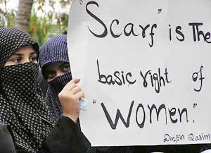 Pakistani women display a placard during a rally in Karachi on Thursday against a proposed ban on head scarves in schools in France. 