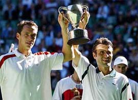 Fabrice Santoro and Michael Llodra of France hold the trophy after winning the men's doubles final against Bob Bryan and Mike Bryan of the US 