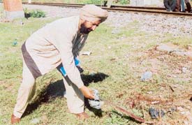 A police official examines the weapon from the murder site on the Ferozepore