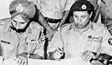 Pakistan's Lieut-Gen Amir Abdullah Khan Niazi signs the surrender document after the 1971 war with India, as India's Lieut-Gen Jagjit Singh Aurora looks on