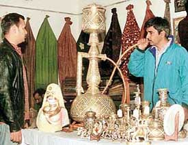 Visitors try the “hookah” during the Andhra Pradesh handicrafts exhibition at the