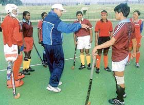 Chief coach M.K. Kaushik gives vital tips to the womens hockey team at a practice session at the National Stadium in New Delhi.