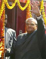 Prime Minister Atal Bihari Vajpayee waves before boarding a special train after he inaugurated a mega-bridge on river Saryu