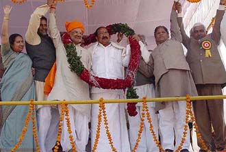 BJP chief Venkaiah Naidu and Union Labour Minister Sahib Singh Verma share a garland as party MPs from Haryana wave to the crowd during the shankhnaad rally at Gohana
