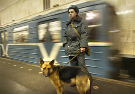 A soldier stands in front of a departing train on the platform of the Avtozavodskaya metro station in Moscow 