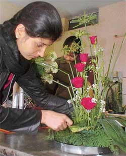 A student adjusts a flower during the inter-college flower arrangement contest at Khalsa College for Women, Ghumar Mandi