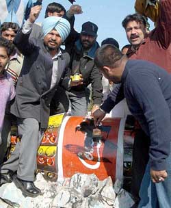 All-India Anti-Terrorist Front activists blacken a hoarding with a Coke advertisement in Amritsar on Wednesday in protest against products of Coke and Pepsi companies.