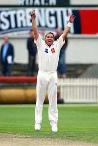 Shane Warne celebrates taking his first wicket during his comeback match after completing his one year drug suspension 