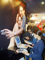 An exhibitor shows visitors the features of a laptop at eastern India's biggest computer exhibition