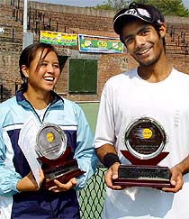 Pichittra Thongdach of Thailand and Navdeep Singh of India pose with their trophies after winning the ITF Juniors tennis tournament at the CLTA courts