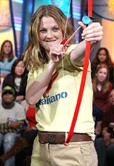 Actress Drew Barrymore plays cupid with a bow and arrow