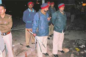 Policemen carry swords seized from a taxi operator's office near Lakshmi cinema in Ludhiana