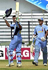 Indian batsman Shikhar Dhawan waves to the crowd after reaching his century while partner Suresh Raina looks on at the Bangabandhu Stadium in Dhaka 
