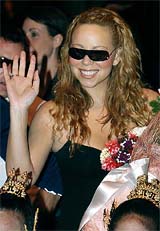American pop diva Mariah Carey waves after arriving at Bangkok's international airport
