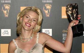 American actress Scarlett Johansson shows her best actress award for her role in Lost in Translation at the British Academy Film Awards ceremony in London