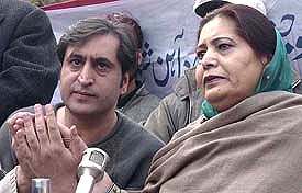 Sajjad Lone, Chairman of the Jammu Kashmir Peoples Conference, holds his mothers hand during a Press conference in Srinagar
