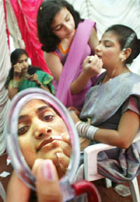 Job applicants for the positions of cabin crew apply make-up prior to their interviews with recruitment officers of Air-India in Mumbai on Friday. 