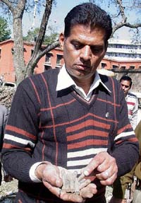 A member of the Forensic Department, Chandigarh, displays live cartridges of an AK-47 rifle