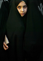 An Iranian stands in line with an older relative waiting to cast her ballot