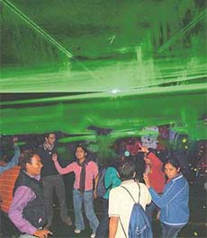 Students dance under the special effects created by the laser show at Panjab University on the concluding evening of Jhankar-2004 in Chandigarh