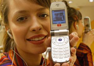 Model Bianca displays the first UMTS mobile phone, capable of receiving and transmitting live video images in a Duesseldorf shop.