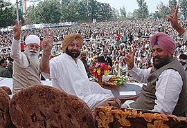 PPCC President H.S. Hanspal, Punjab Chief Minister Amarinder Singh and PWD Minister Partap Singh Bajwa flash victory signs at a rally in Qadian