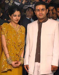 Indian cricketer Virender Sehwag and his fiance Arti Singh pose for photographers