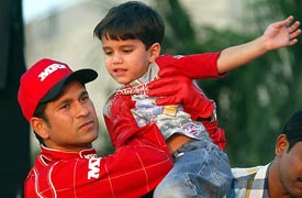 Master blaster Sachin Tendulkar holds his four-year-old son Arjun while promoting kart racing at a racing circuit in Mumbai