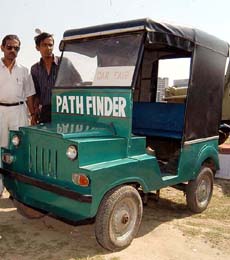 Sanjay Karmakar and owner Uday Banerjee explain the details of 'Path Finder', a small four-seater diesel car built by them and priced at Rs 42,000, at the Automobile Fair 2004 