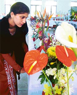 A young girl admires flowers at a flower show in PAU
