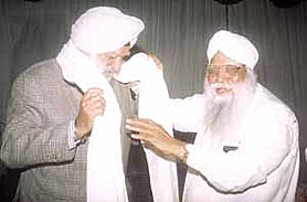 Delhi Sikh Gurdwara Management Committee president Prahlad Singh Chandok honouring Sri Guru Tegh Bahadur Khalsa College chairman Justice Kuldip Singh with a siropa.