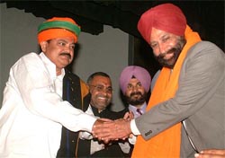 Former Deputy Commissioner of Amritsar Sarbjit Singh shakes hand with BJP President Venkaiah Naidu in Amritsar on Monday