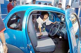 A woman tries out the two-seater Maruti-Suzuki car called Twin, on display at the Automobile Fair 2004, in Kolkata on Monday.
