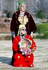 Two South African tourists sport traditional Kashmiri costumes at Muhgal Garden in Srinagar 