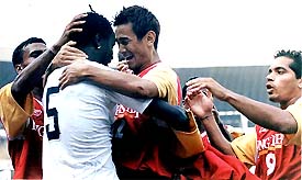 East Bengal's Baichung Bhutia celebrates with Mike Okoro after scoring against getting Goal Against Negeri Sembilan in Kolkata on Wednesday