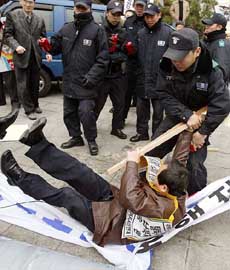 South Korean policemen scuffle with protesters as they try to burn a North Korean flag at a rally near the US Embassy in Seoul on Wednesday.