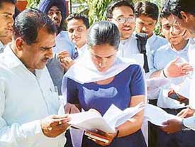 A man talks to her daughter regarding the question paper outside an examination centre in Sector 15
