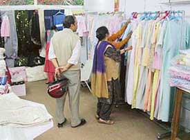 Visitors inspect exquisitely embroidered garments at an exhibition