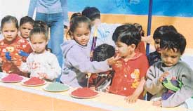 Kids of Cutes Nursery School play Holi with water guns and colours on Wednesday