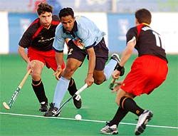 Indias Kamaldeep Singh controls the ball while Belgiums Dennis Dijkhoorn and Charles Vandeweghe try to stop him