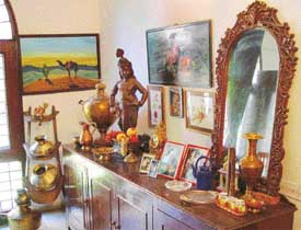 A camel seat and old vessels adorn the corner of the dining area.