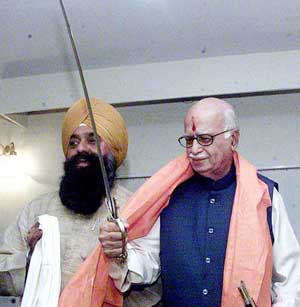 One of the members of a Sikh delegation presents a sword to Deputy Prime Minister L.K. Advani prior to his departure for Bharat Uday Yatra